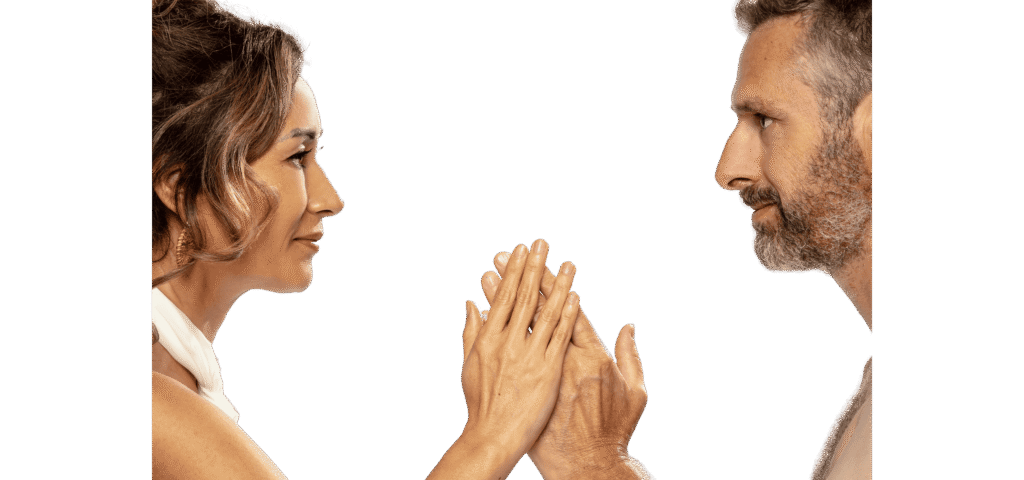 Ein Paar, das sich mit Handflächen berührt und tief in die Augen blickt, symbolisierend Verbindung, Achtsamkeit und die Essenz der Tantra Massage.