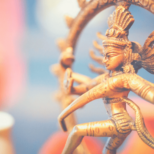 Eine detaillierte goldene Shiva Nataraja Statue, die den kosmischen Tänzer darstellt, symbolisierend Schöpfung, Erhaltung und Zerstörung sowie die dynamische Energie und Transformation in der Tantra Massage und spirituellen Praxis.