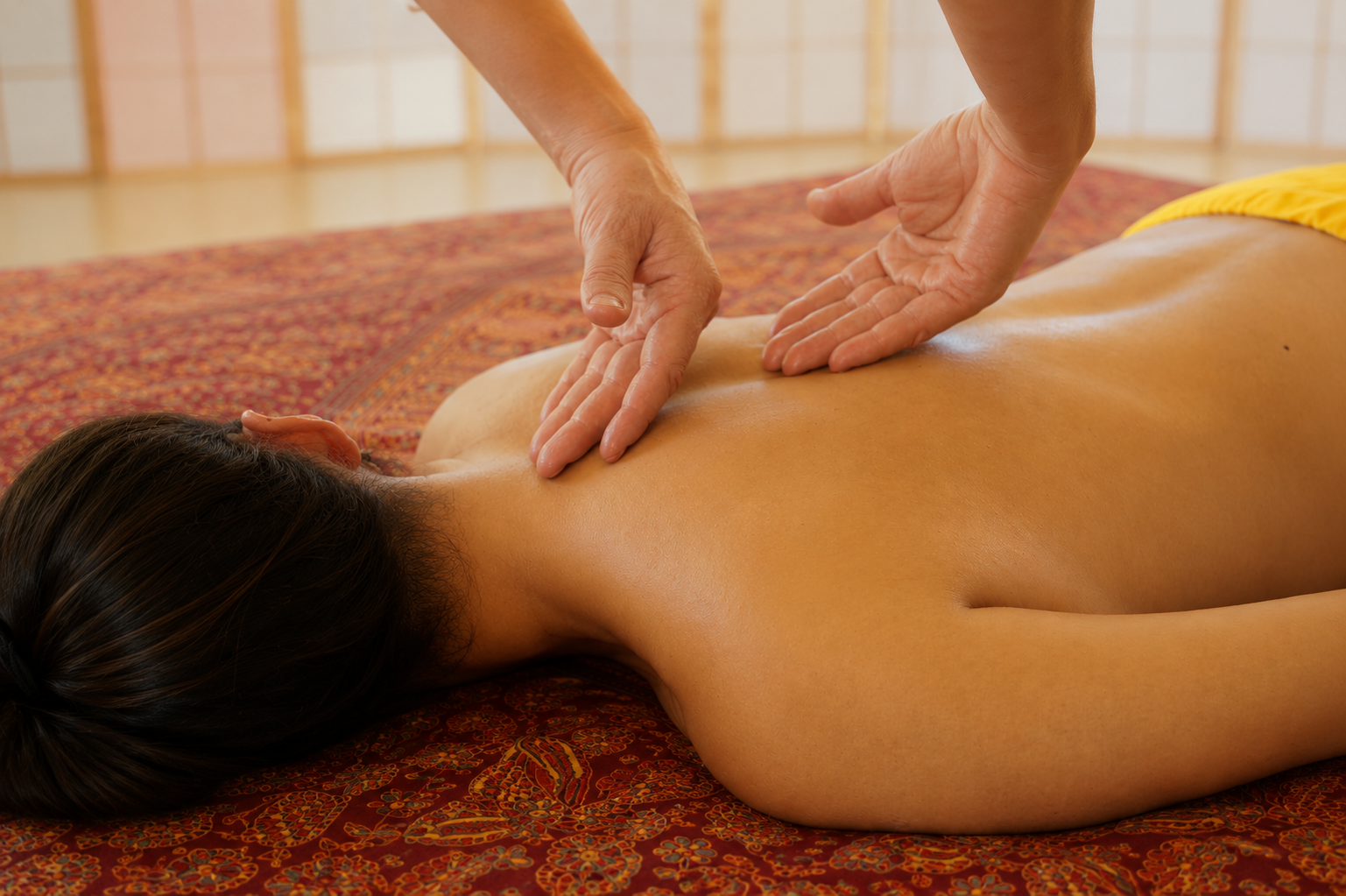 Praktische Tantra-Massage: Sanfte, achtsame Berührungen am Rücken während einer Massageübung.